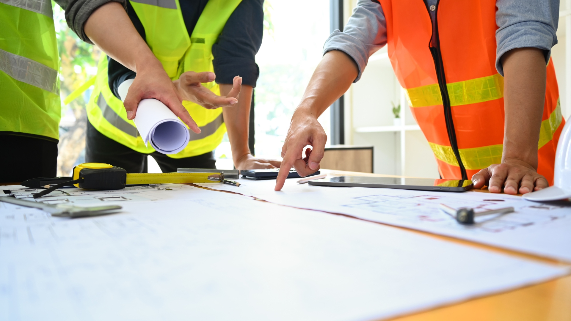 Construction team looking at building drawings and various resources